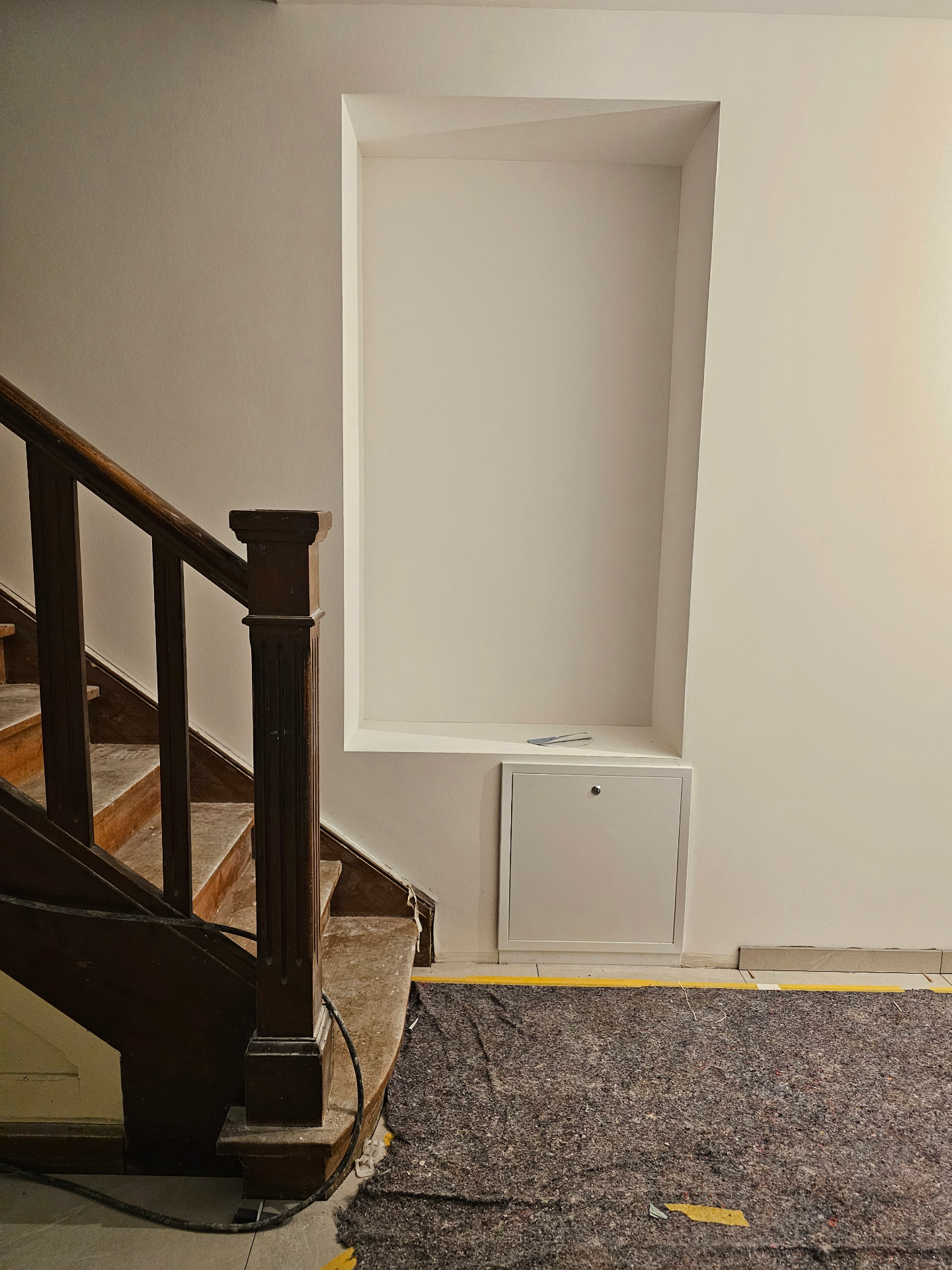 Original wooden staircase next to a freshly built wall niche